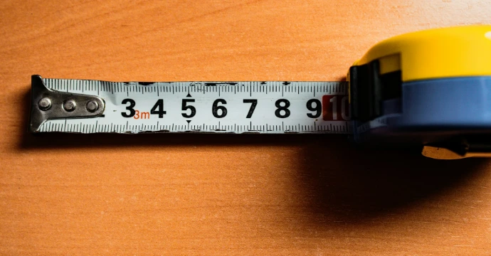 A tape measure is on a wooden table